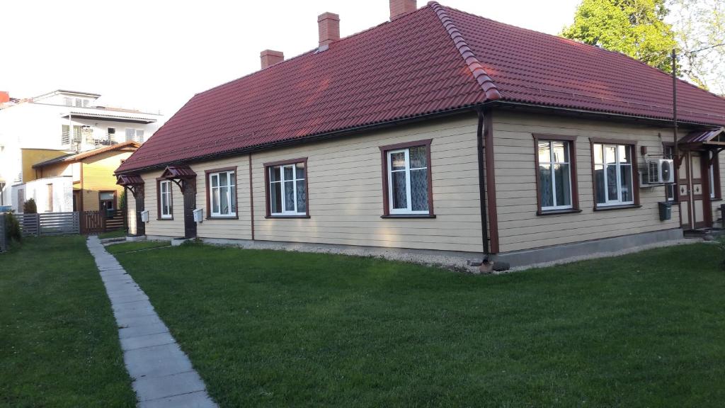 a small house with a red roof on a yard at Vingi Apartment 12 in Pärnu