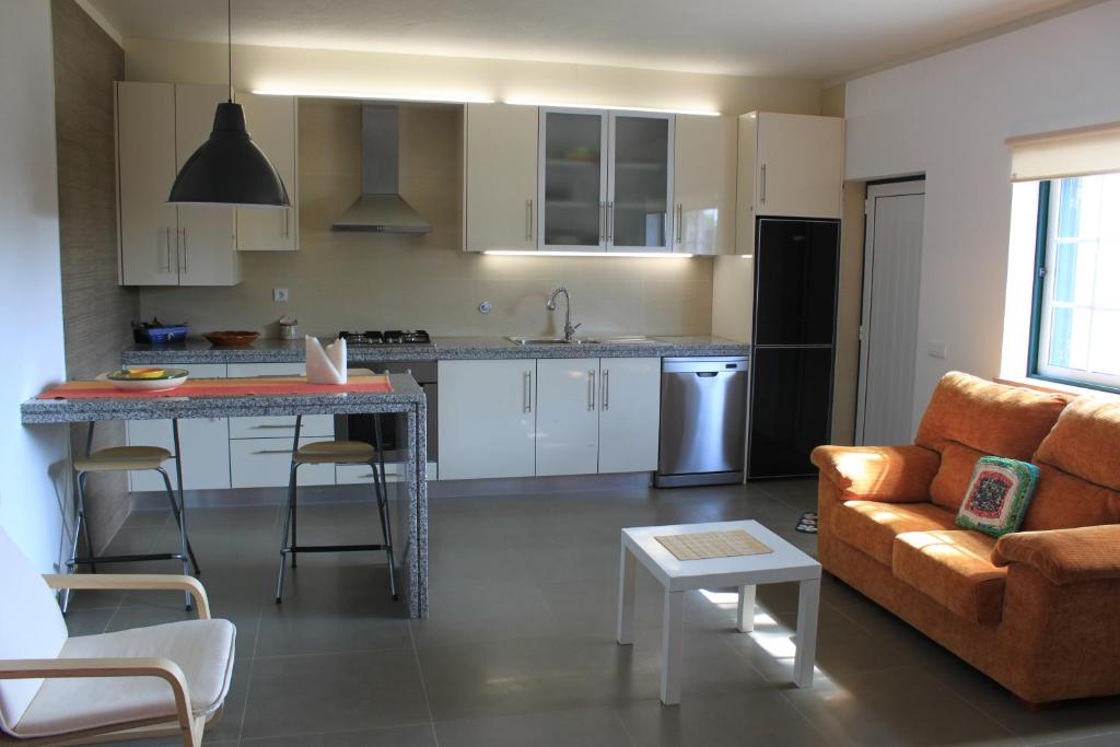a kitchen and living room with a couch and a table at Avo das Bolachas nº 12 in Nazaré