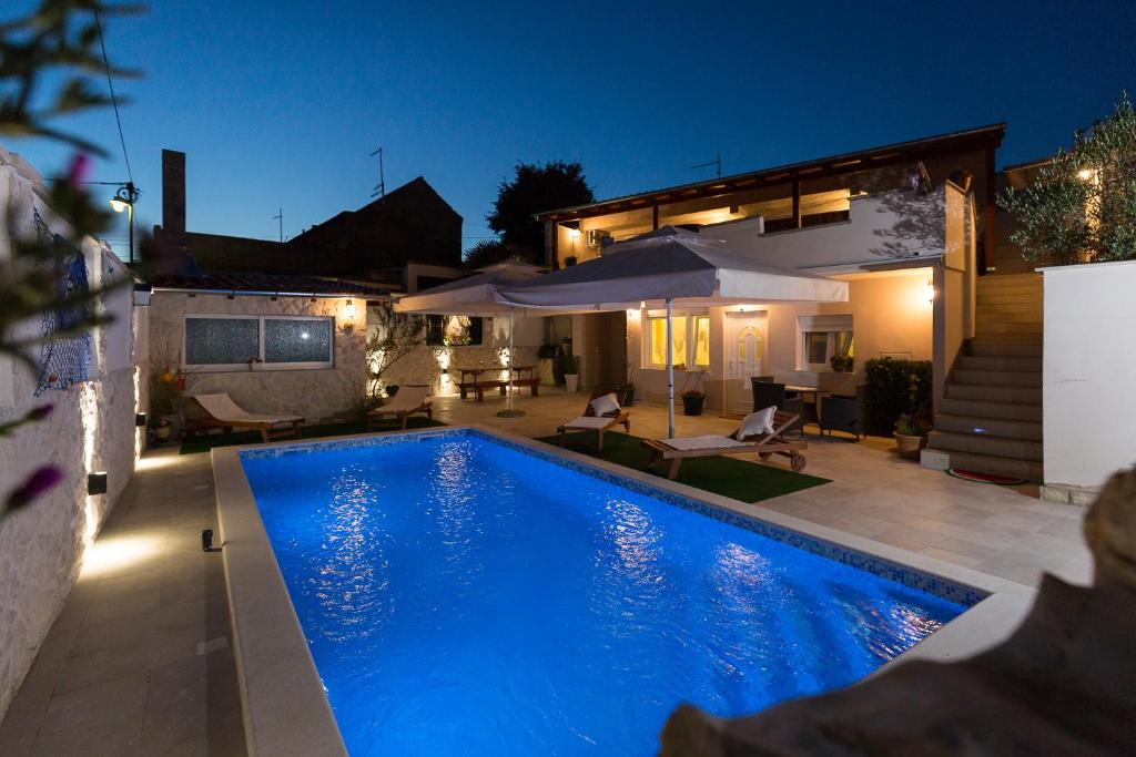 una piscina en el patio trasero de una casa por la noche en Apartment Nedo, en Sveti Filip i Jakov