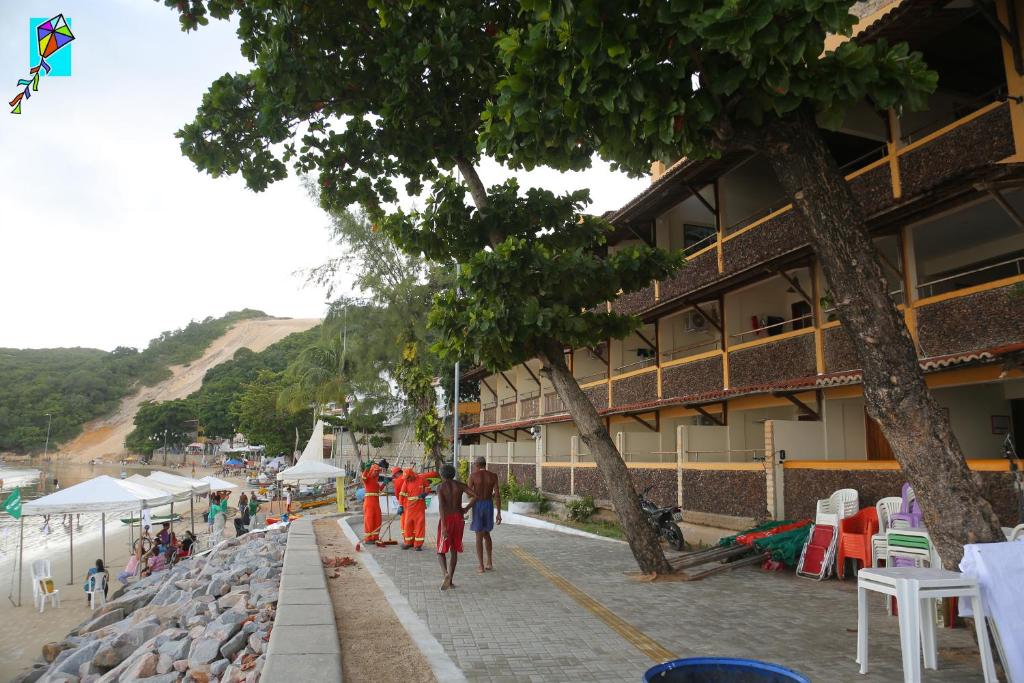 een groep mensen die op een stoep naast een gebouw lopen bij Hotel Morro do Careca in Natal