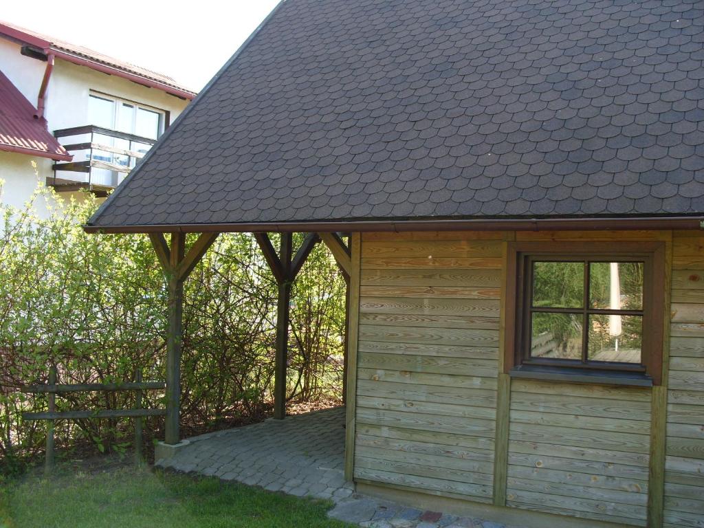 Cabaña de madera con techo inclinado y ventana en Domek Sara en Przytarnia