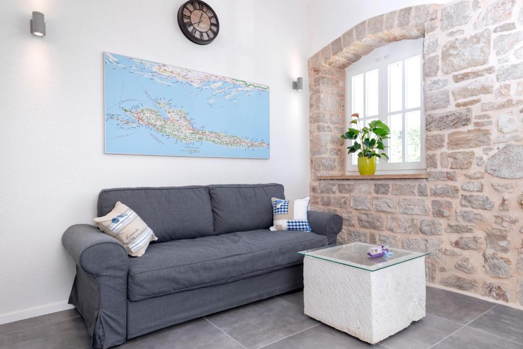 a living room with a couch and a clock on the wall at Villa Riva in Jelsa