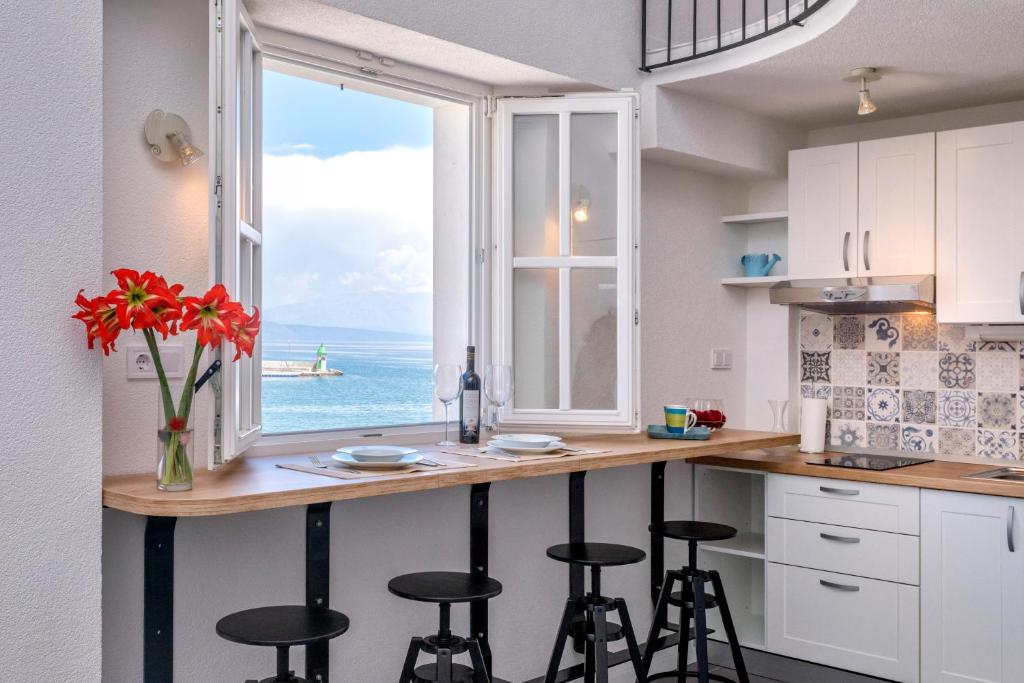 a kitchen with a counter with stools and a window at Villa Riva in Jelsa