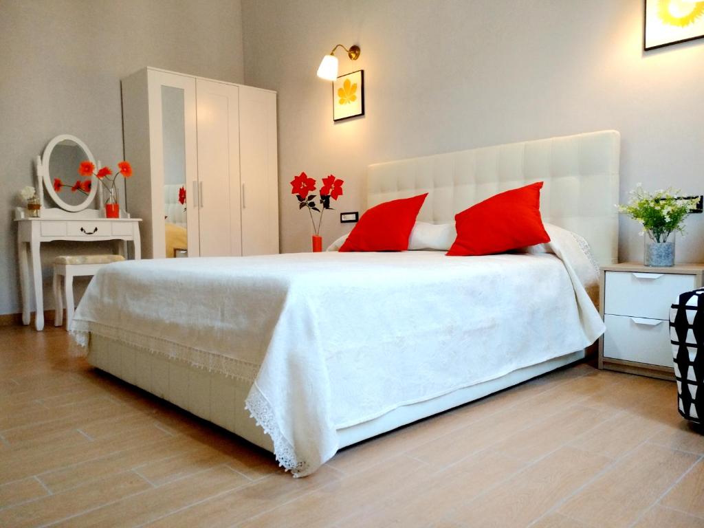 ein Schlafzimmer mit einem großen weißen Bett mit roten Kissen in der Unterkunft Apartment Nice Venice in Mestre