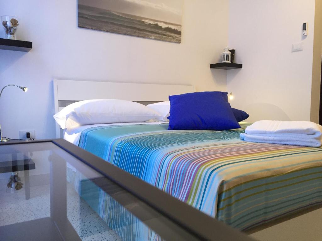 B&B Portarotese في ساليرنو: غرفة نوم مع سرير وبطانية مخططة ملونة