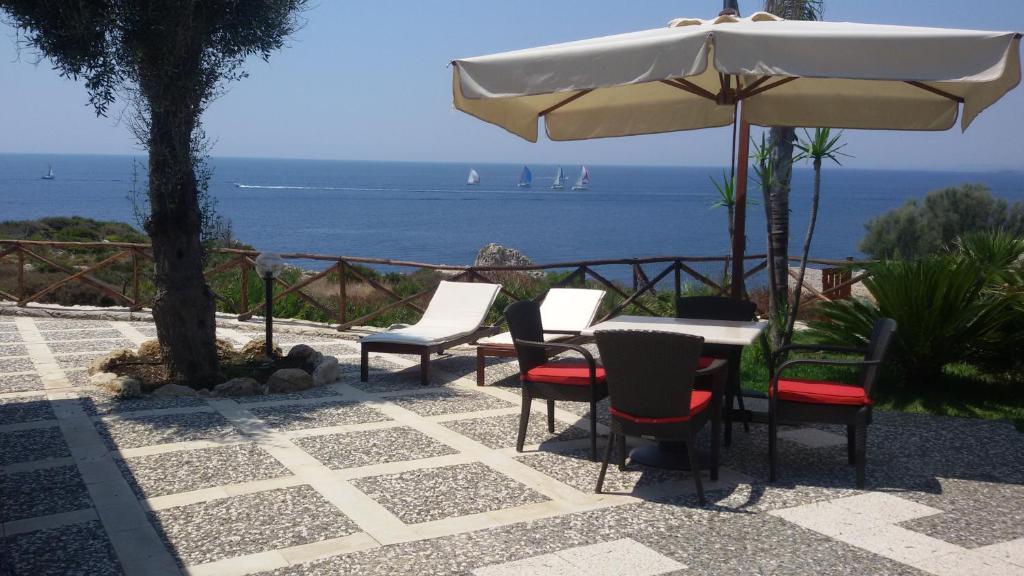 シラクーサにあるCasa Costanzaのテーブルと椅子、パラソルと海