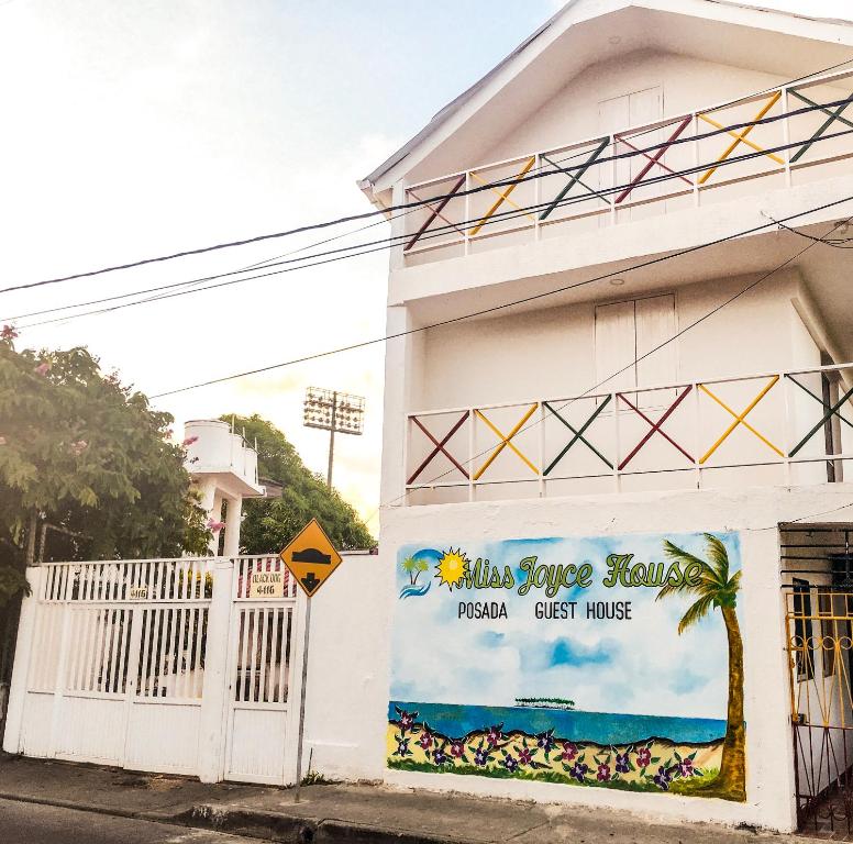un edificio blanco con un cartel en el costado en Posada Miss Joyce House en San Andrés