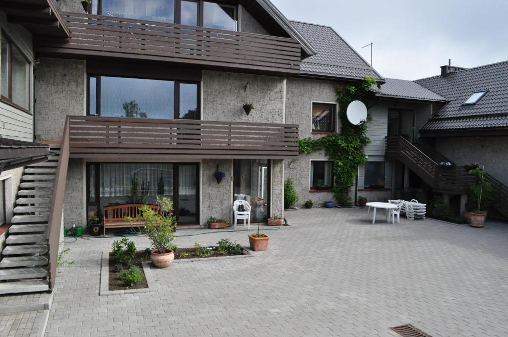 a house with a patio with a wooden deck at Molo Užeiga Inn in Klaipėda