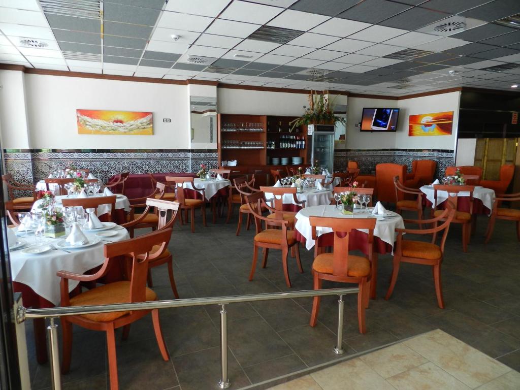 un comedor con mesas y sillas en un restaurante en Hotel La Familia, en El Campello