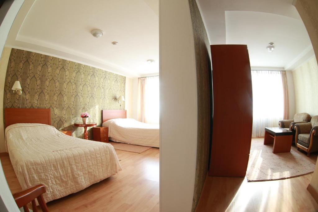 a bedroom with a bed and a room with a bed and a couch at Hotel Turist in Yuzhno-Sakhalinsk