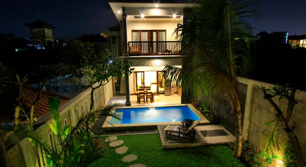 a house with a swimming pool in the yard at The Surya Kuta Villa in Kuta