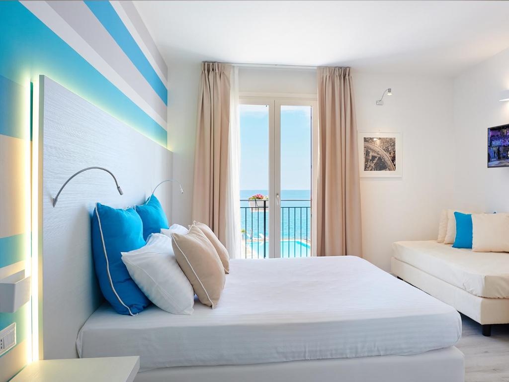una camera con letto e vista sull'oceano di Marina di Petrolo Hotel & SPA a Castellammare del Golfo