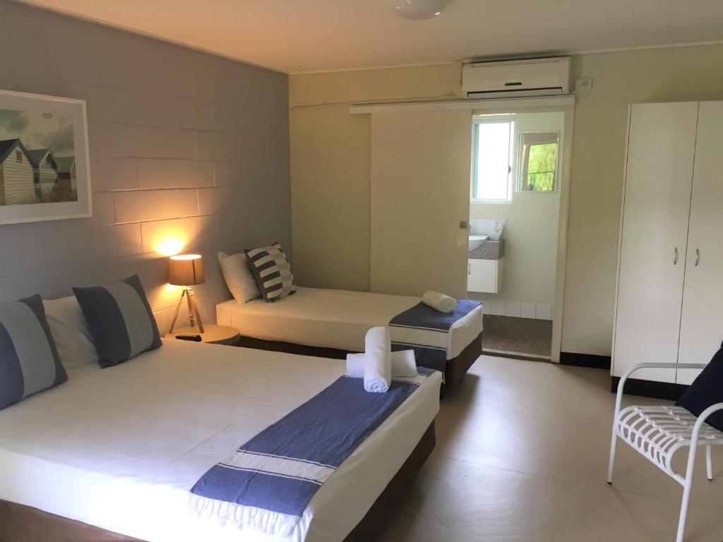 a hotel room with two beds and a television at Cardwell at the Beach in Cardwell