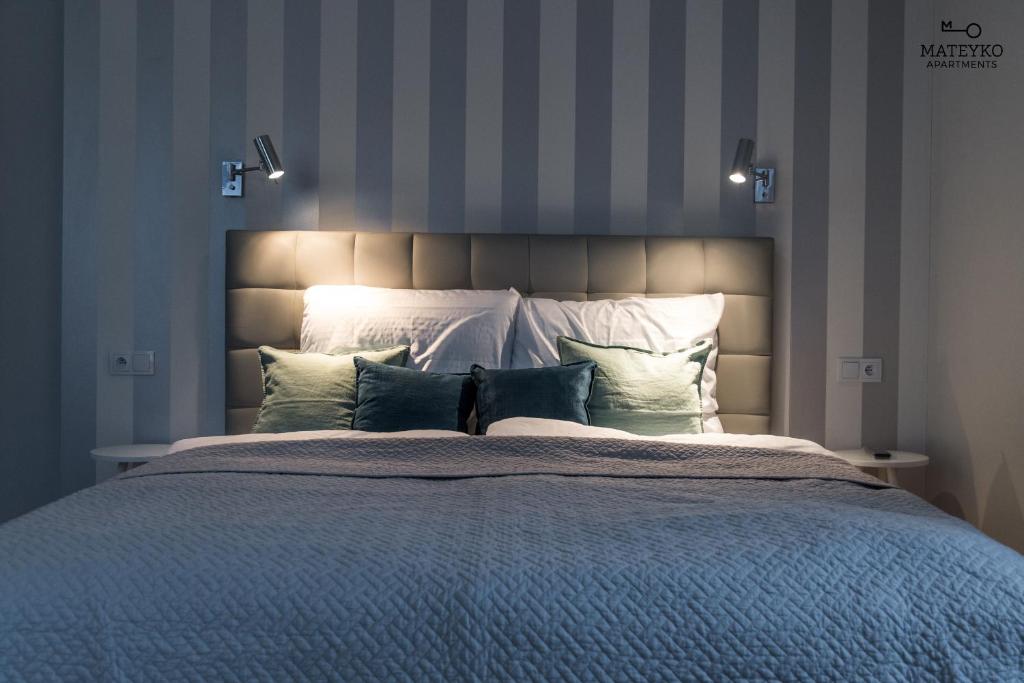 1 dormitorio con 1 cama grande con almohadas en Mateyko Apartment en Cracovia
