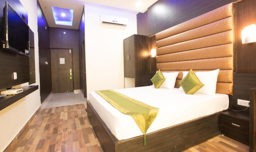 a bedroom with a large bed and a television at Vibhav Grand in Haridwār