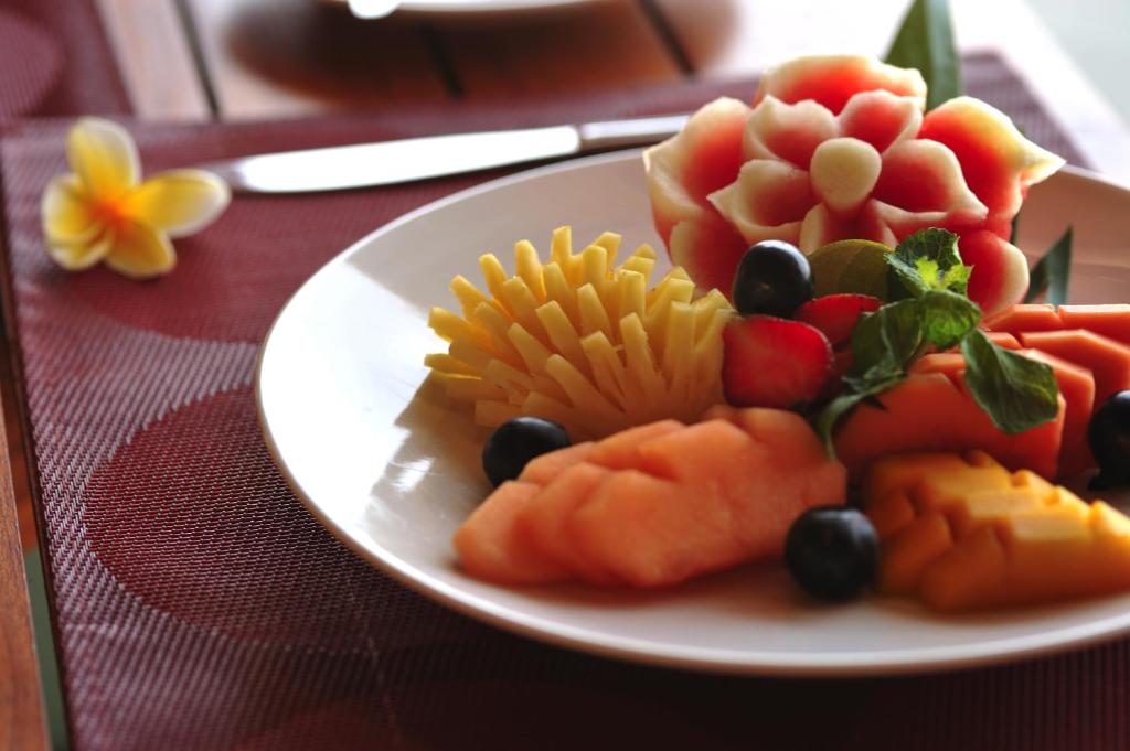 a plate of fruit and vegetables on a table at Cocotinos Sekotong Lombok in Sekotong