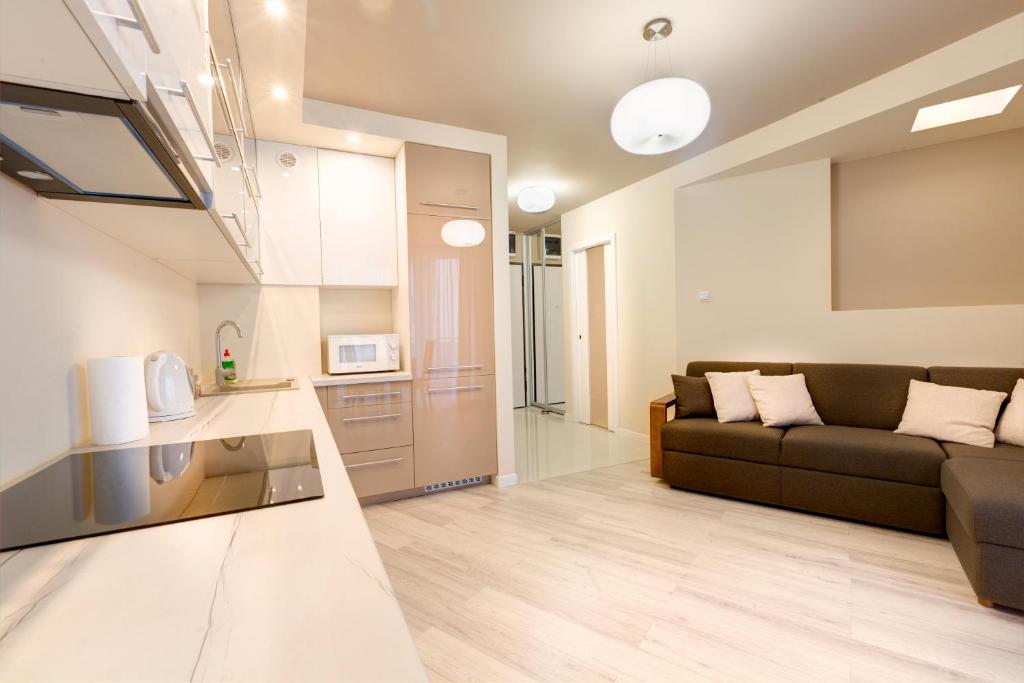 salon z kanapą i kuchnią w obiekcie Apartment Royal III w mieście Białystok