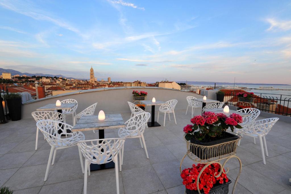 eine Terrasse mit Tischen und Stühlen auf dem Dach in der Unterkunft Bajamonti 5 Luxury Rooms in Split