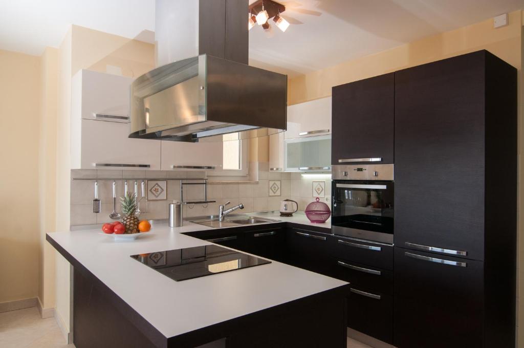 a kitchen with black cabinets and white counter tops at Ičići Bellevue in Ičići