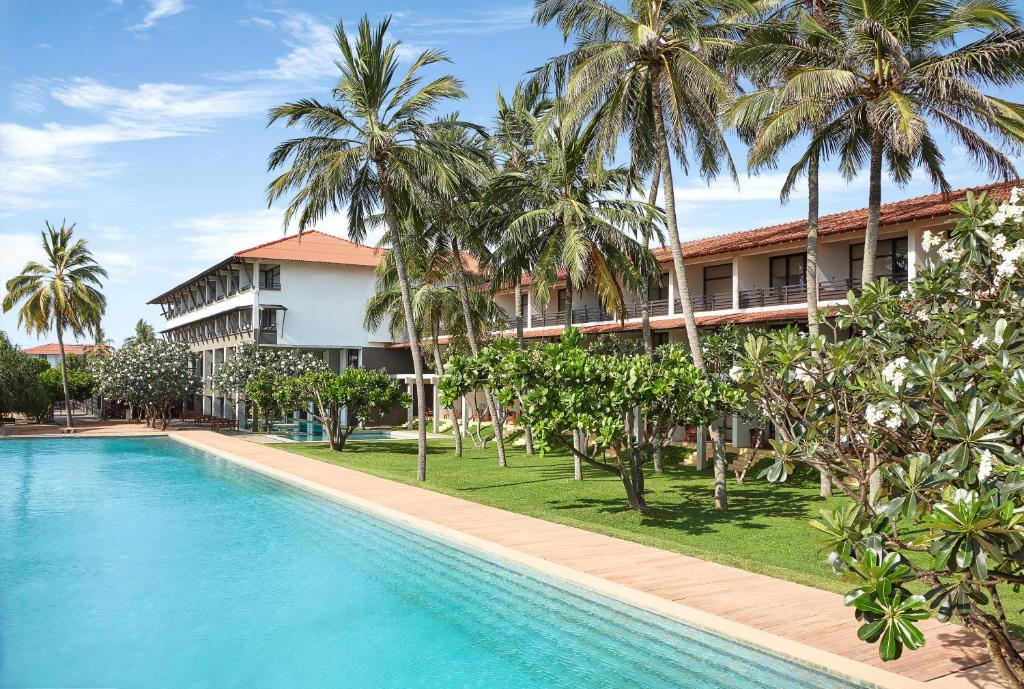uma imagem de um resort com uma piscina e palmeiras em Jetwing Beach em Negombo