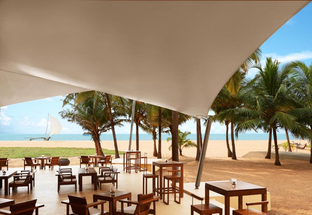 a restaurant on the beach with tables and chairs at Jetwing Beach in Negombo