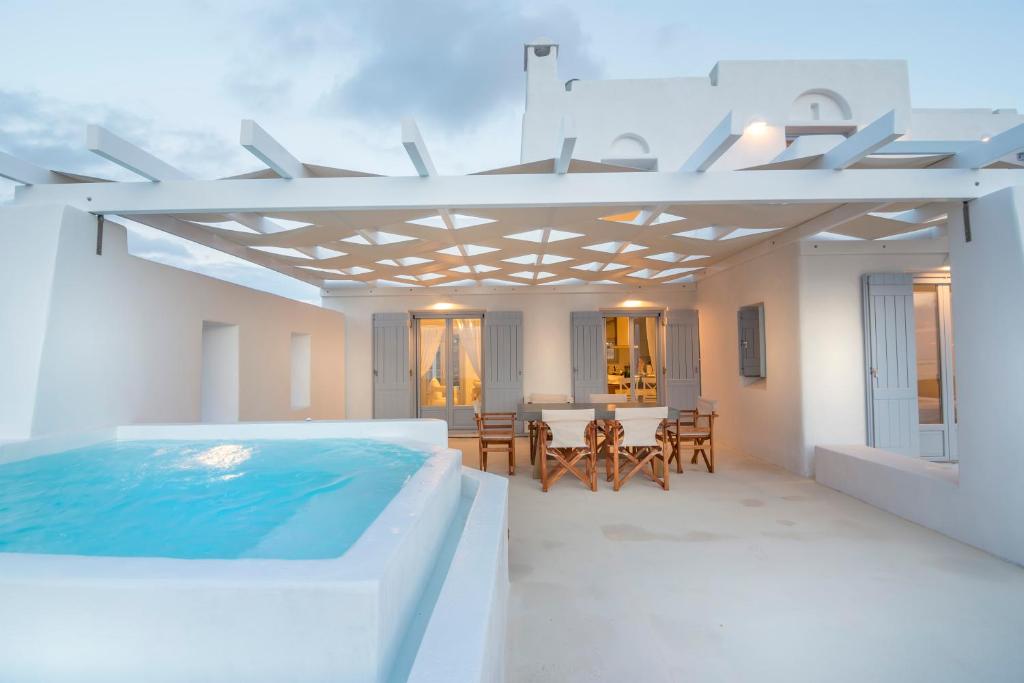 a room with a pool and a table and chairs at Passos Villas in Parasporos