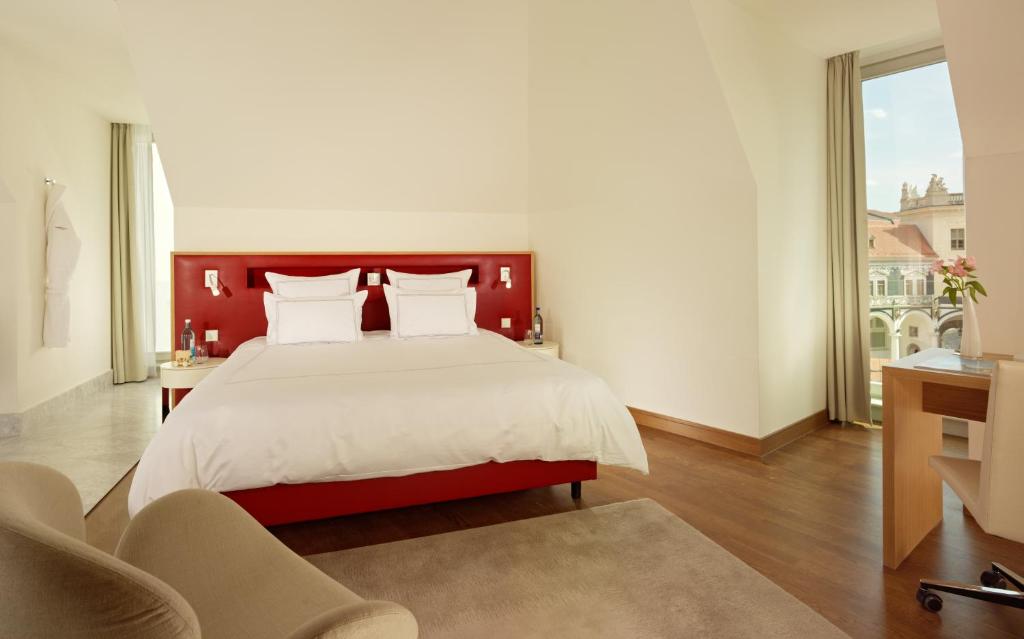 a bedroom with a large bed and two chairs at HYPERION Hotel Dresden Am Schloss in Dresden