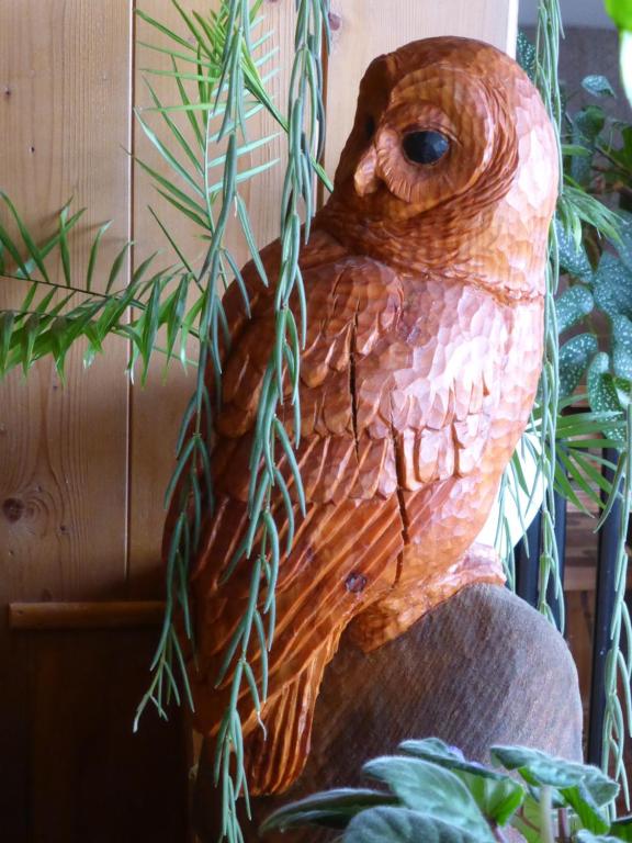 a statue of an owl sitting on a chair at Pension Alpina in Lenk
