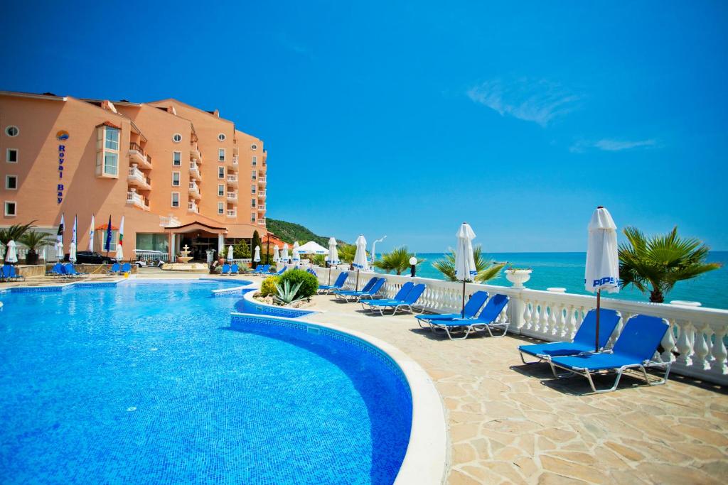 a resort with a swimming pool and chairs and the ocean at Royal Bay Hotel - All Inclusive in Elenite