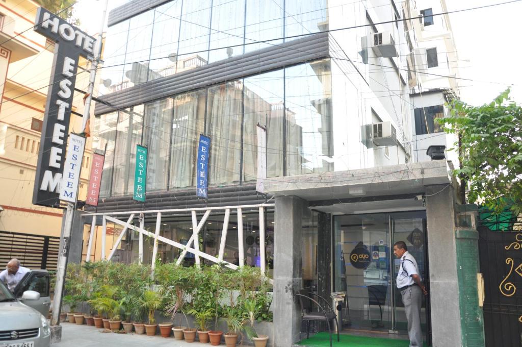 a man is standing outside of a building at Hotel Esteem in Kolkata