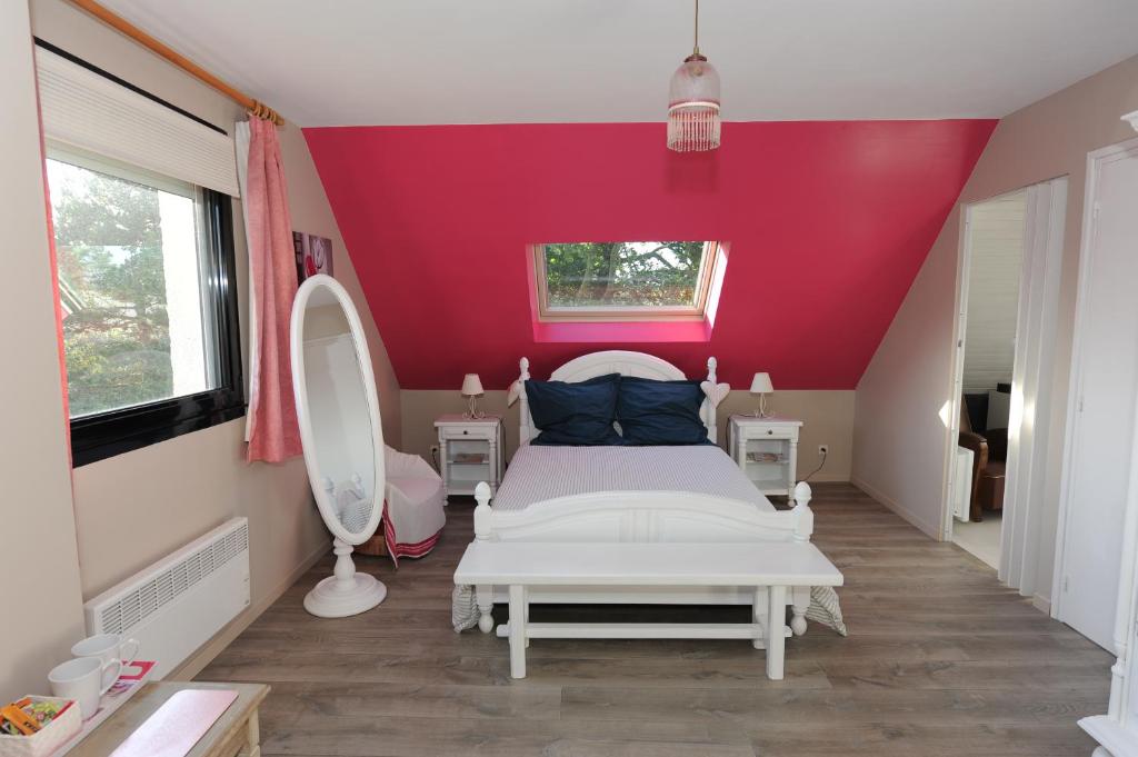 a bedroom with a white bed and a red wall at Aux doux Becots - Bed & Breakfast in Hardelot-Plage