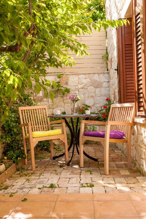 two wooden chairs and a table and a table and a table and chairs at Villa Eftichia in Stalos