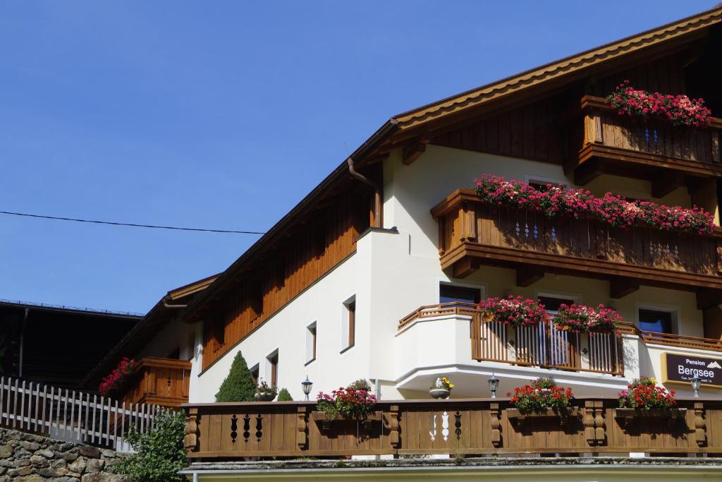 een wit gebouw met bloembakken en balkons bij Pension Bergsee in Sölden