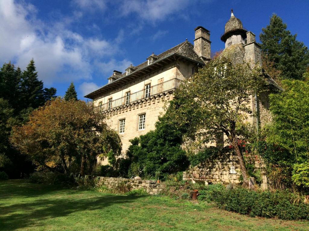 ein altes Steingebäude mit einem Baum davor in der Unterkunft B&B Chateau le Bois in Saint-Julien-aux-Bois