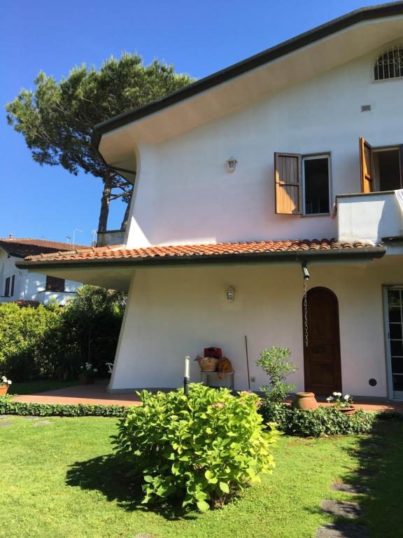 a white house with a window and a yard at Holiday home Villetta Cinquale in Cinquale