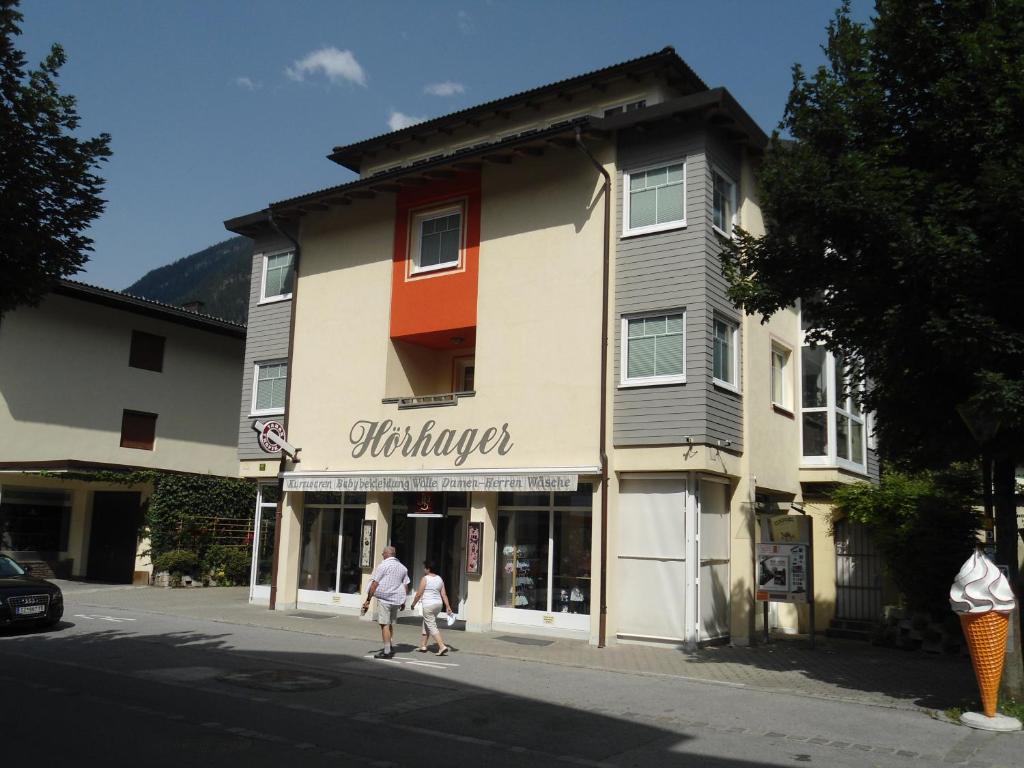 two people walking down a street in front of a building at Apartment Hörhager in Mayrhofen
