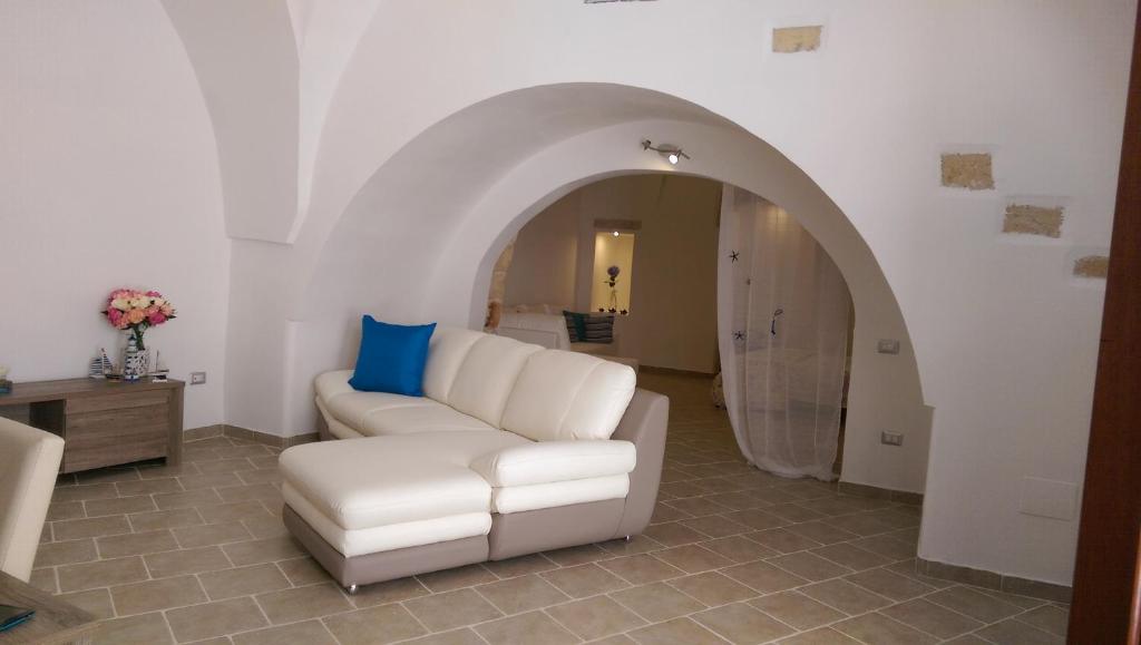 a living room with a white couch and an archway at Rifugio di Sole in Copertino