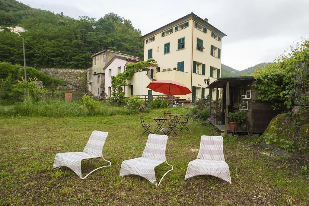 four white chairs and a table and a building at Cà di Gatti Apartment in Ne