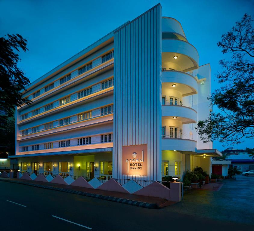 a hotel building with a lit up facade at night at Grand Hotel in Cochin