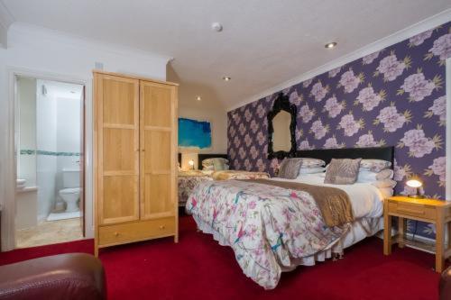 a bedroom with a bed and a dresser at Clifton Bridge Guesthouse in York