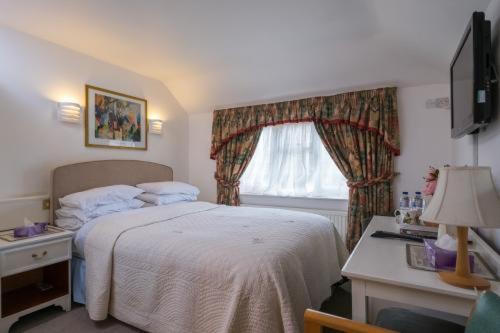 a bedroom with a white bed and a window at Clifton Bridge Guesthouse in York