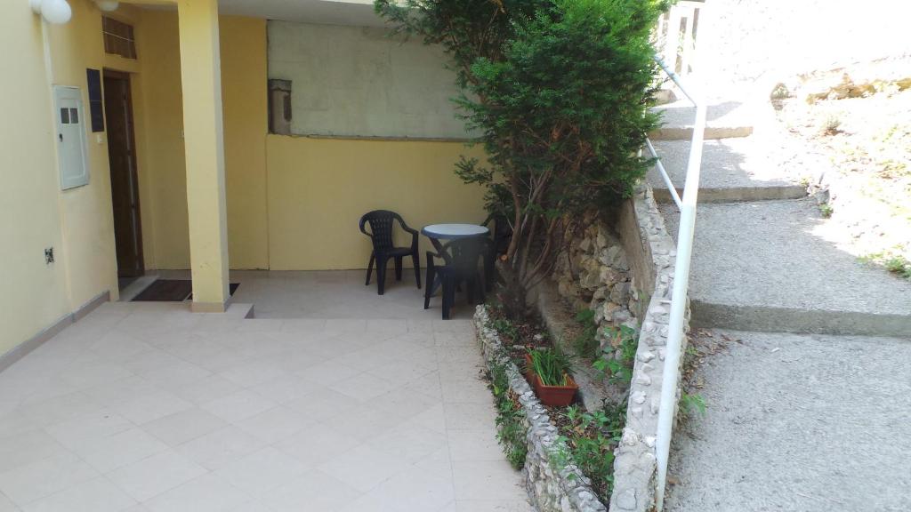 a patio with chairs and a table next to a building at Apartments Andrea in Baška