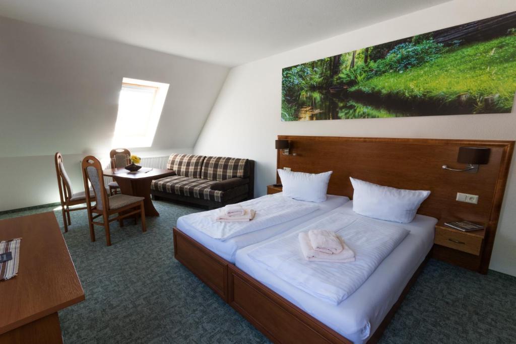 a hotel room with a bed and a couch and a table at Gasthof zum Slawen in Vetschau