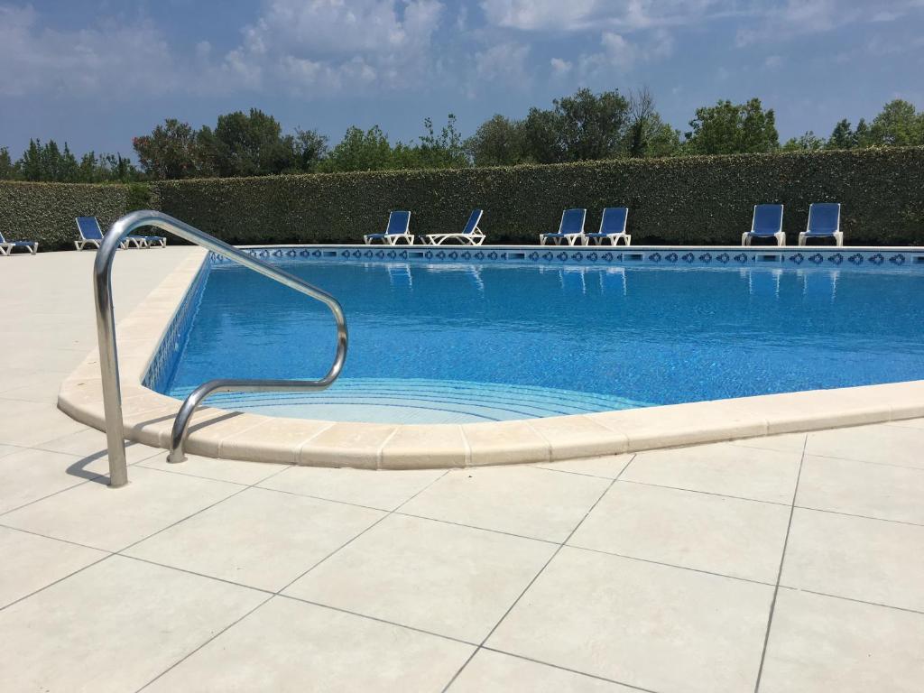 uma grande piscina com cadeiras e aicrobialicrobialicrobial em L'Ecume em Saint-Cyprien