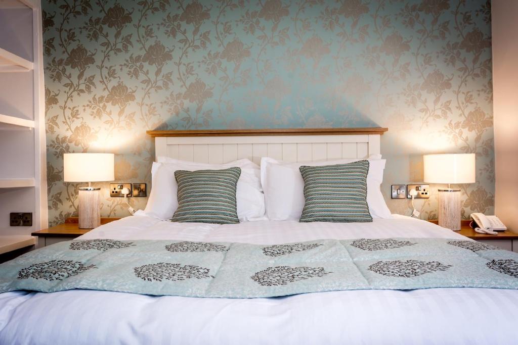 sypialnia z białym łóżkiem z 2 lampami w obiekcie Penhelig Arms w mieście Aberdyfi
