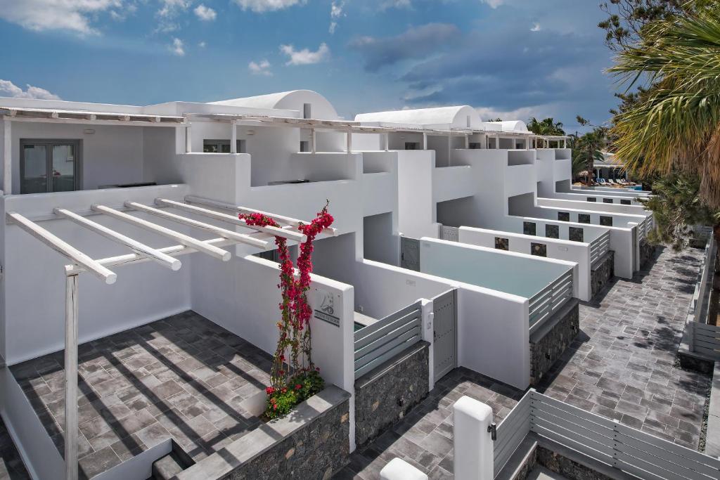 a white building with a cross on the side at Meltemi Excelsior Suites in Perissa
