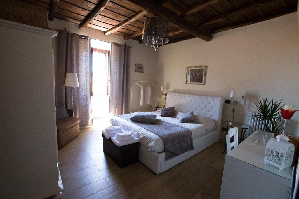 a bedroom with a large white bed in a room at La finestra sul borgo in Bracciano
