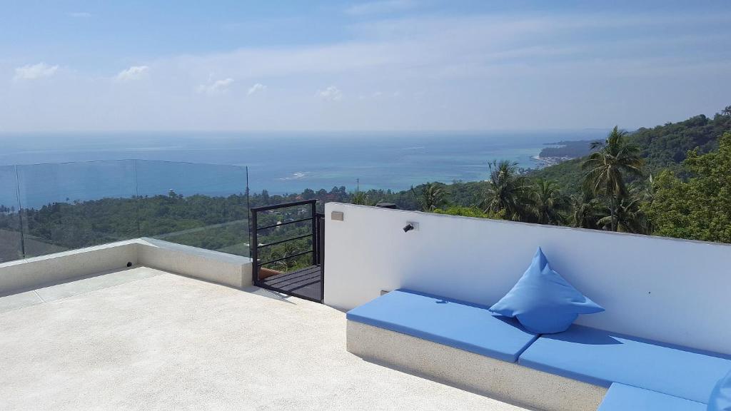 a blue couch sitting on top of a balcony at COCOON Villa Lamai Koh Samui in Lamai