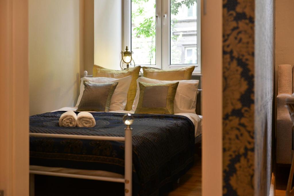 クラクフにあるLa Gioia Magic Orient Apartmentsのベッドルーム1室(枕付きのベッド1台、窓付)