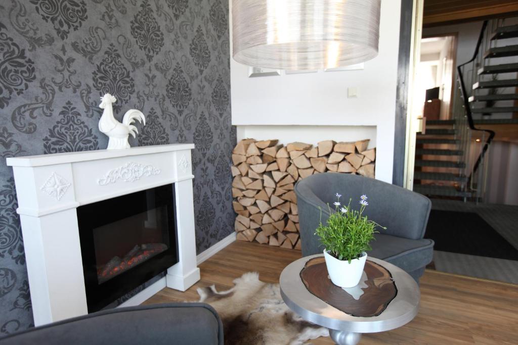 a living room with a fireplace and a chair at Pension Gockels-Auszeit in Bad Wildungen